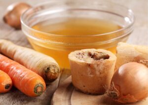 Carrots and a cup of bone broth which is a good food for arthritis and sore muscles.