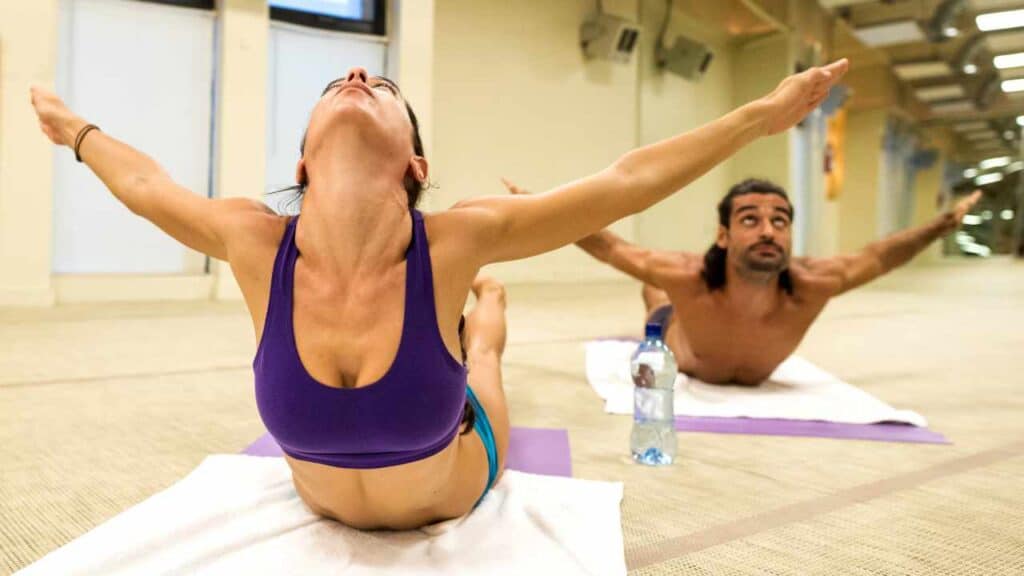 Girl and guy doing hot yoga thinking about the best electrolyte water brands and best electrolytes for hot yoga