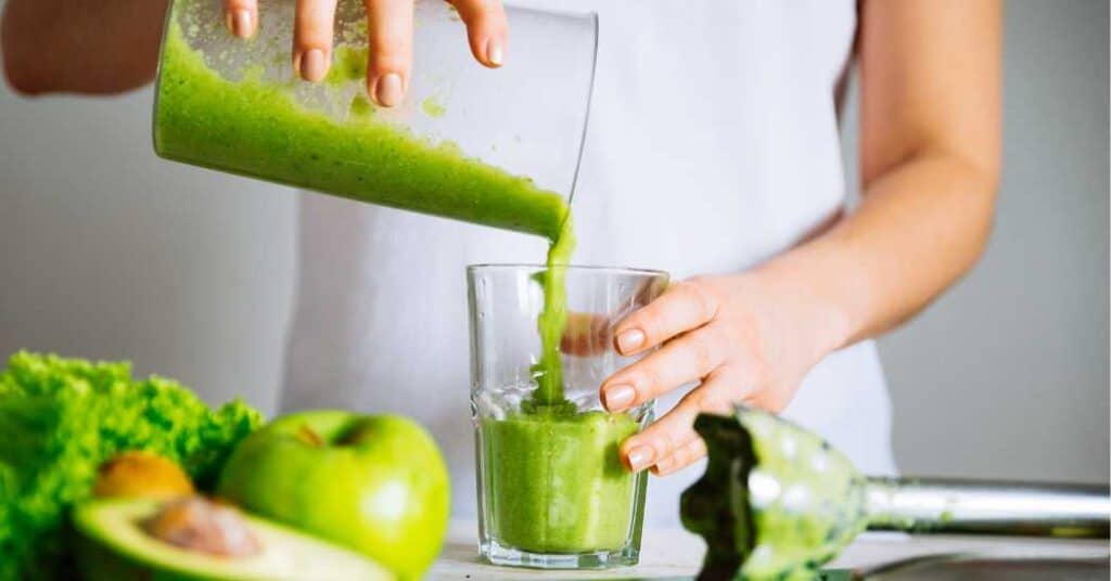 Female making a green smothie to boost her detoxification in an effort to help recover from mold illness. 