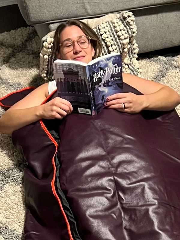 Abby reading Harry Potter as she enjoys infrared sauna blanket treatment