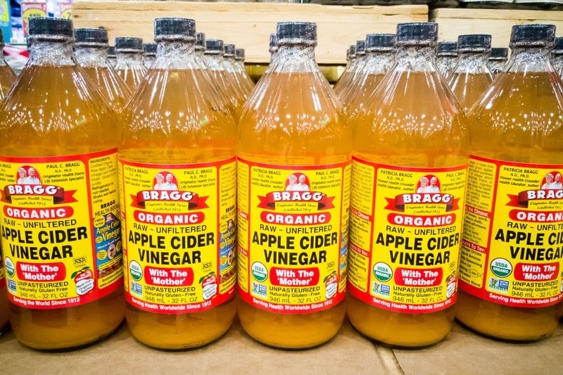 Bottles of Bragg Apple Cider Vingegar at a store showing "With the Mother" which is part of the health benefits of apple cidar vinegar and honey drinks. 