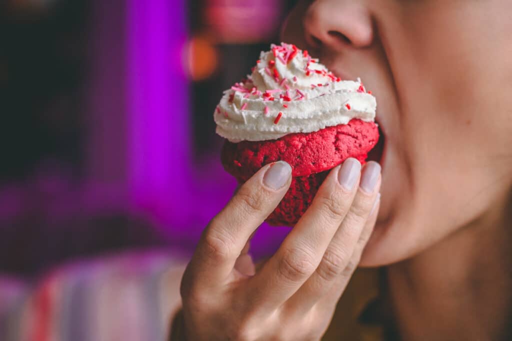 Girl eating a sugar-laden cupcake which is a food additive endocrine disruptor