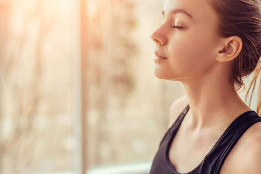 Girl breathing to reduce stress and thinking about cortisol supplements and the best supplements to reduce cortisol naturally. 