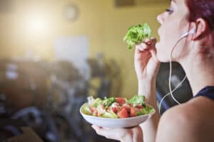 Plant based athlete eating salad after working out. 