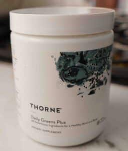 Bottle of Thorne Daily Greens Plus greens powder supplement